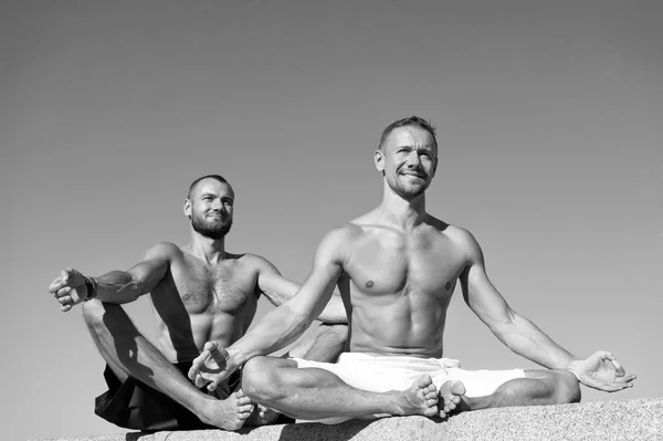 Het bereiken van evenwicht op grond van yoga. Sport en gezondheidszorg. Dagelijkse oefeningen om gezondheid te behouden. Gezondheid en yoga praktijk. Op weg naar gezondheid. Mannen praktijk yoga buiten. Gespierde mannen training op frisse lucht — Stockfoto