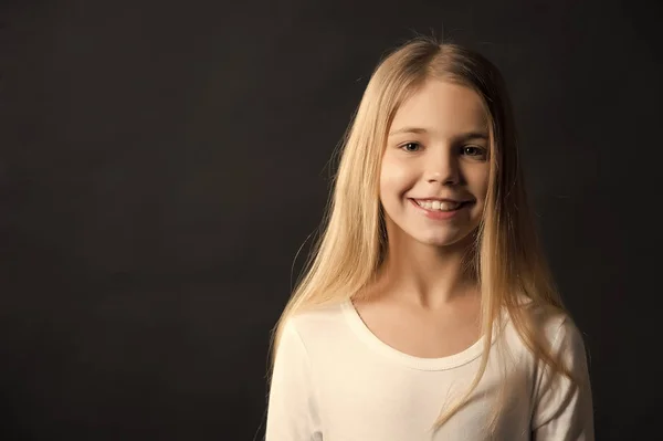 Menina com sorriso no rosto bonito no fundo escuro — Fotografia de Stock