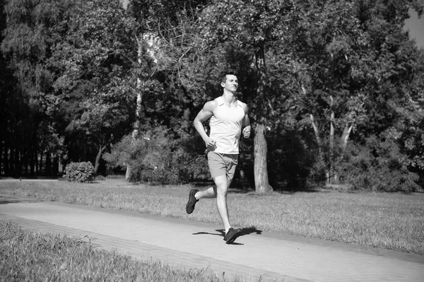 Su mejor velocidad. Hombre corredor ejecutar en parque día soleado fondo de la naturaleza. Hombre entrenando, prepara su cuerpo para la maratón. Desafío deportivo popular maratón para mejorar a ti mismo. Únete a morning jog community —  Fotos de Stock