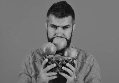 Baştan çıkarıcı yüzü olan çiftçi kırmızı elma kokusu alıyor. Sakallı adam