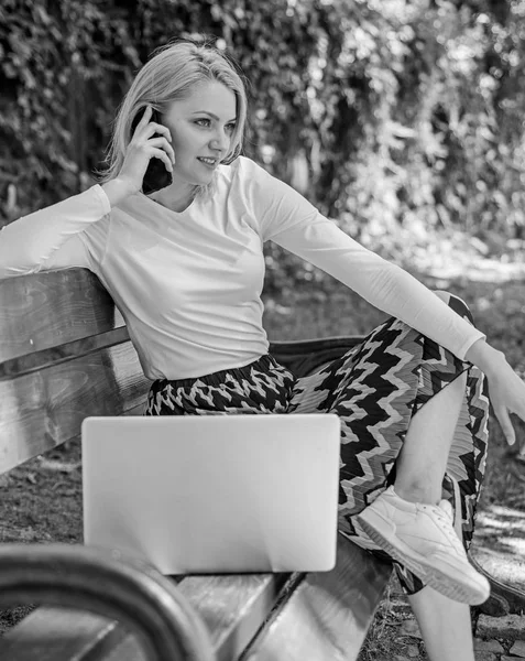 Girl dreamy takes advantage of online shopping. Girl sit bench with notebook call phone. Save your time with shopping online. Shopping online. Woman laptop in park enjoy green nature and fresh air