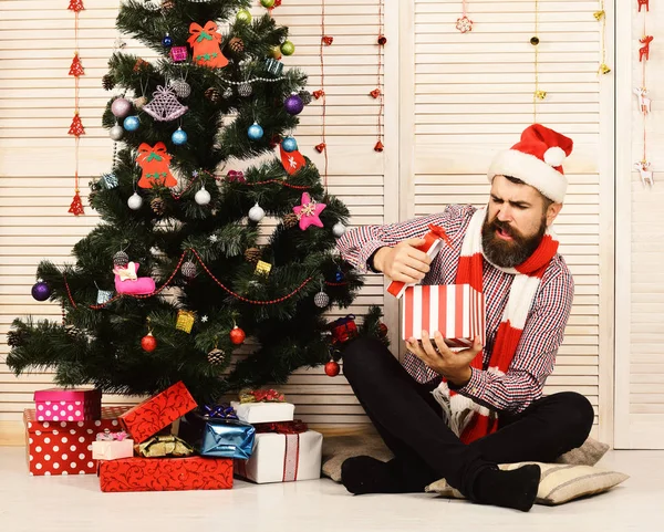 Kerstman met teleurgesteld gezicht op rode slingers achtergrond — Stockfoto