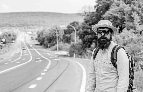 Un hombre al borde de la autopista buscando transporte. En el camino. Hitchhiking significa transporte que ganó pidiendo a extraños para montar en su coche. Autoestopista tratar de detener el transporte para llegar a destino —  Fotos de Stock