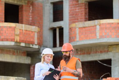 İnşaat ekibi iletişim kavramı. İnşaat istemcileri ve inşaat sektöründe katılımcılar arasındaki ilişkiler. Planı tartışıyor. Kadın mühendis ve Oluşturucu inşaat alanında iletişim