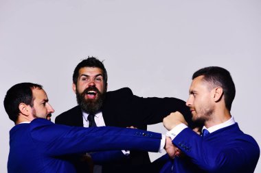 Resmi takım elbiseli, ciddi ve kızgın yüzlü iş adamları.