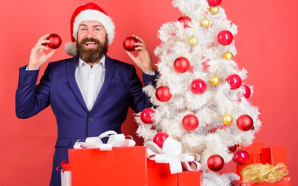 Santa držet vánoční koule dekorace. Veselé Vánoce. Vánoční atmosféra se šíří kolem. Přidáte kouzlo svátků. Muž vousatý opotřebení formální oblek a klobouk santa. Podnikatel se vánoční oslava — Stock fotografie