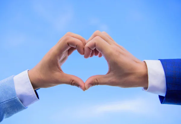 Férfi kezét a szív alakú megfelelő kézmozdulat-szimbólum a szeretet és a romantika. Szerelmi szimbólum fogalom. Kézzel szív gesztus formák alakú ujját. Kéz össze a szív alakú kék ég háttér — Stock Fotó
