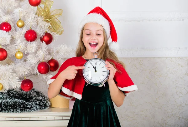 Nový rok countdown. Dívka dítě santa klobouk kostým držet hodiny vzrušený výraz šťastný obličej počítat čas do nového roku. Last minute do půlnoci. Silvestr plán na poslední chvíli. Veselé Vánoce koncept — Stock fotografie