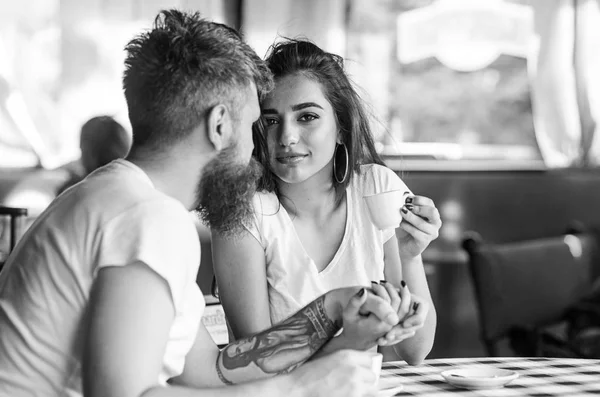 Поделитесь романтическими чувствами с чашкой кофе. Мужчина с бородой и привлекательная счастливая улыбающаяся девушка пьет кофе. Влюбленные пьют черный кофе эспрессо в кафе. Пара счастливых провести время в кафе — стоковое фото