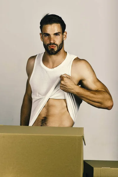 Hombre mostrando torso sexy entre cajas de cartón — Foto de Stock