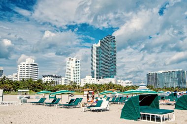 Yeşil şemsiye altında sandalyelere insanlarla rahatlatıcı Sandy beach