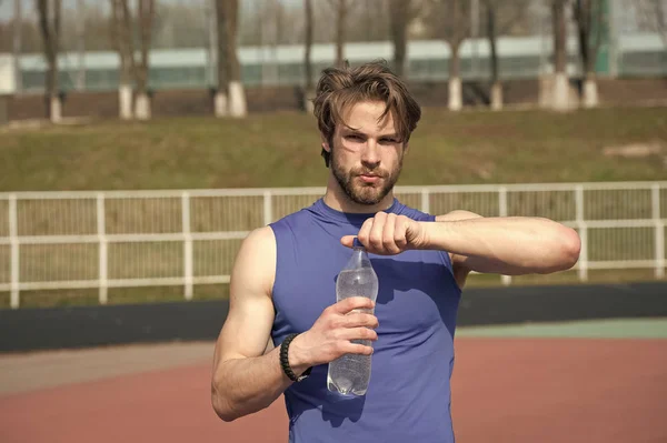 Guapo musculoso hombre sostiene botella de agua — Foto de Stock