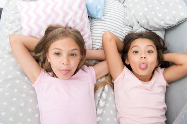 Çocuklar neşeli bir ruh hali içinde birlikte eğleniyorlar. Pijama partisi ve arkadaşlık. Kız kardeşler yatak odasında dinlenen mutlu küçük çocuklar. Küçük kızların arkadaşlığı. Boş zaman ve eğlence. En iyi arkadaşımla eğleniyorum.