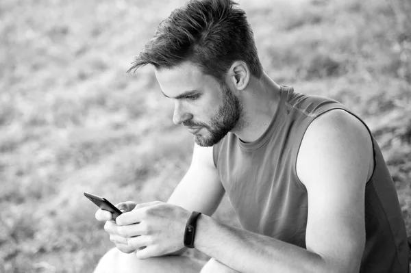 Fique online e disponível. Sportsman texto sms no ar fresco. Homem relaxar com smartphone na grama verde. Atividade de verão. Sempre em contacto. As tecnologias facilitam o treinamento. Blog de esporte e weblog — Fotografia de Stock