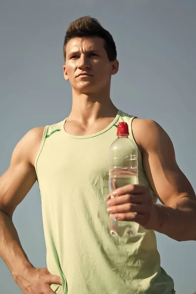 Человек с бутылкой воды в мускулистых руках — стоковое фото