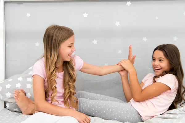 Αδελφές αναψυχής. Κορίτσια στο χαριτωμένο πιτζάμες περνούν χρόνο μαζί στην κρεβατοκάμαρα. Αδελφές επικοινωνούν ενώ Χαλαρώστε στην κρεβατοκάμαρα. Οικογένειά του χρόνου. Ανακοίνωση της αδελφές. Παιδιά Χαλαρώστε και διασκεδάζοντας με το βράδυ — Φωτογραφία Αρχείου