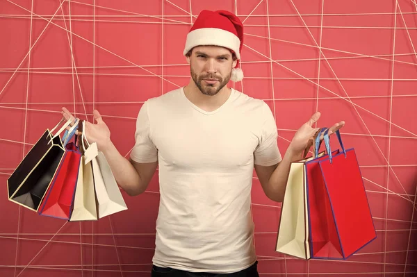 赤い帽子でマッチョな買い物客は、paperbags を保持します。 — ストック写真