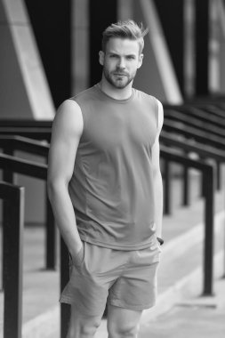 Sportif giyim, kentsel arka plan ciddi yüzünde kıl olan adam. Spor moda kavramı. Adam sakallı ve çekici görünümü ile ilgili umurunda değil. Sakal veya şık spor giysileri tıraşsız adam adam