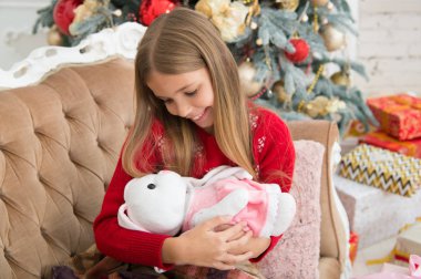 Küçük kız kucak Noel ağacı sevimli tavşana. Küçük kız tavşan oyuncak tutun. Yumuşak oyuncak ile küçük çocuk oyun. Küçük çocuk mevcut ile gülümseyen mutlu. En iyi Noel oyuncak. Tavşanım seviyorum.
