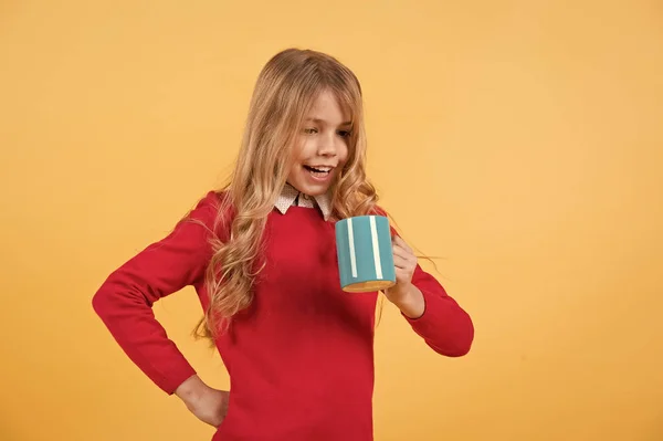 Kind glimlach met blauwe beker op oranje achtergrond — Stockfoto