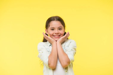 Gülen bebek. Heyecan dolu. Kız mutlu güler yüz onun yanakları sarı arka plan dokunur. Öğrenci bir şey hakkında heyecanlı. Çocuk şirin çocuk heyecanlı hissediyorum. Çok şirin. Mutluluk çocukluk