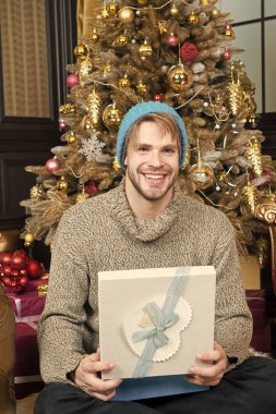 Adam gülümseme şapkalı, şu anda Noel ağacı ile kazak