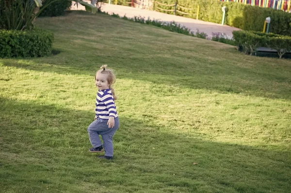 Ragazzo con i capelli biondi correre su erba verde — Foto Stock