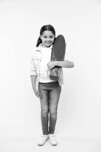 Готовий до їзди. Дівчинка щаслива носить дошку копійки. Дитина любить скейтбординг з дошкою копійки. Сучасне підліткове хобі. Як кататися на скейтборді. Дівчина щасливе обличчя несе дошку копійки жовтого фону — стокове фото
