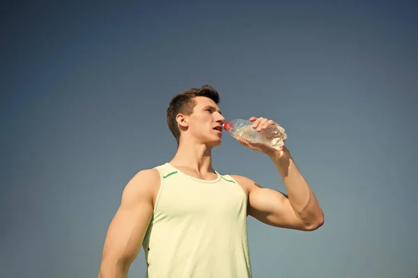 Человек пьет воду из бутылки в солнечный день — стоковое фото