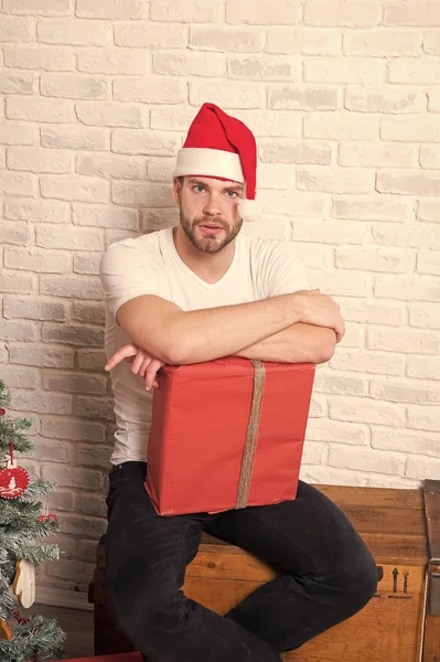Man santa med inslagna julklapp sitta på trälåda — Stockfoto