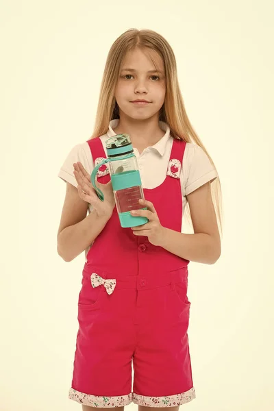 Dziewczynka z plastikowej butelki na białym tle. Spragniony dziecko w różowy kombinezon trzymać butelkę wody. Wody pitnej dla zdrowia. Pragnienie i odwodnienie. Działanie dzieciństwo i energii — Zdjęcie stockowe