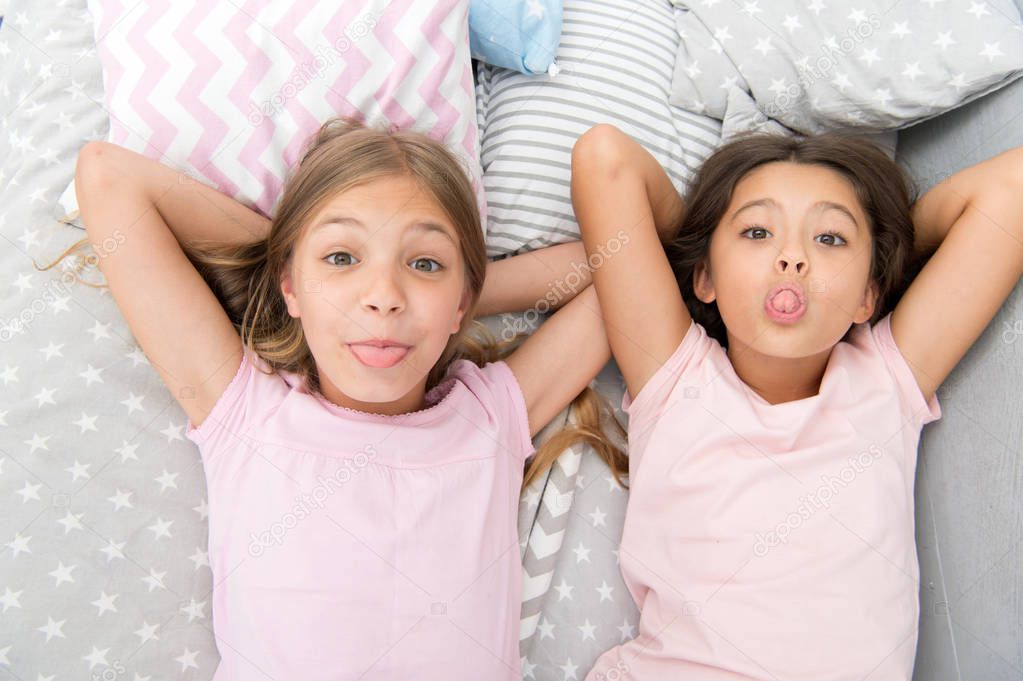 Leisure and fun. Having fun with best friend. Children playful cheerful mood having fun together. Pajama party and friendship. Sisters happy small kids relaxing in bedroom. Friendship of small girls