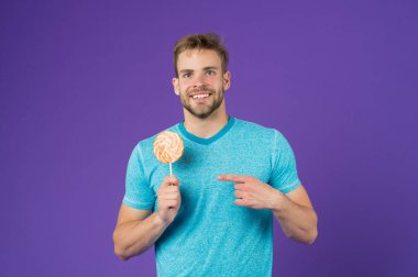 Şeker sağlık için zararlı. Adam lolipop şeker menekşe arka plan tutun. Adam yakışıklı maço büyük renkli tatlı lolipop yemek. Çocukluk tadına. Sakallı adam Lolipop sever. Tatlıya kavramı