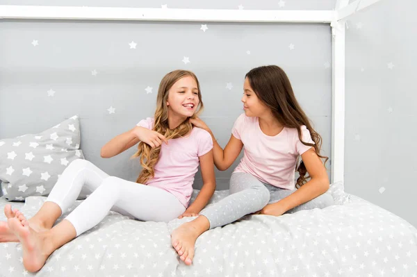 Children relax and having fun in evening. Sisters leisure. Girls in cute pajamas spend time together in bedroom. Sisters communicate while relax in bedroom. Family time. Sisters communication — Stock Photo, Image