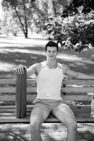 Relax concept. Athlète se détendre sur le banc dans le parc. Sportsman se détendre après l'entraînement de yoga. Détendez-vous et profiter de la vie — Photo