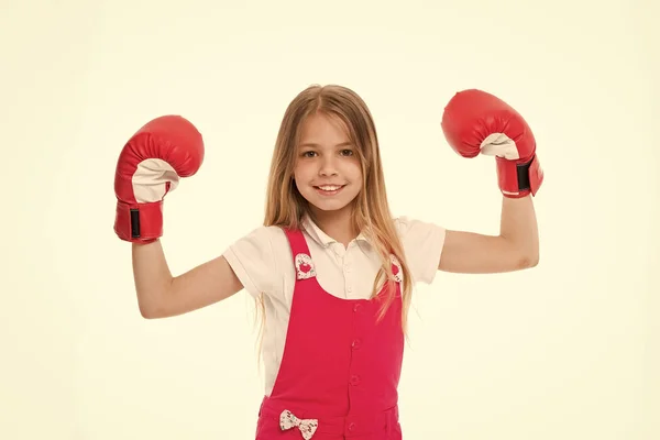 Kid idrottsman Visa makt. Glada barn i boxning handskar isolerade på vitt. Liten flicka leende innan träning eller träning. Barndom och barnomsorg. Sportaktivitet och energi — Stockfoto