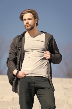 Güneşli açık, moda giyim, sakallı adam. Mavi gökyüzü, perspektif maço kürsüye. Perspektif, gelecek, özgürlük. Erkek moda ve stil