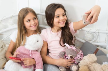 Sanal dünya. Küçük kızlar yatakta telefon kullanın. Noel ve yeni yıl selfie smartphone ile alıyor. Cep telefonu ile mutlu küçük çocuklar. Mutlu Noeller ve mutlu yeni yıl tebrik