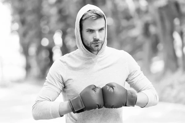 I am ready to fight. Man athlete on concentrated face with sport gloves practicing boxing punch, nature background. Boxer hood head ready to fight. Sportsman boxer training with boxing gloves — Stock Photo, Image