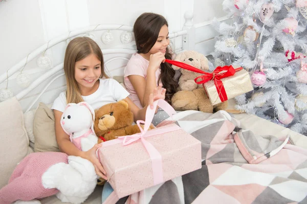Loving each gift they receive. New Year surprise. Happy small children hold gift boxes. Small girls with presents in bed. Merry Christmas and Happy New Year. Opening presents on Christmas morning — Stock Photo, Image