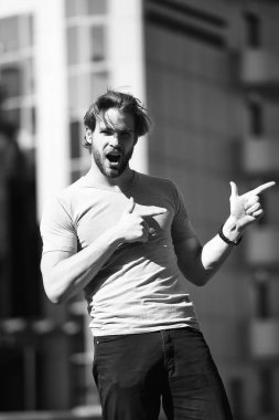 Casual kavramı. Heyecanlı adam rahat kıyafet sokakta parmakları işaret içinde. Casual tarzda. Rahat moda. Sadece şuraya bak