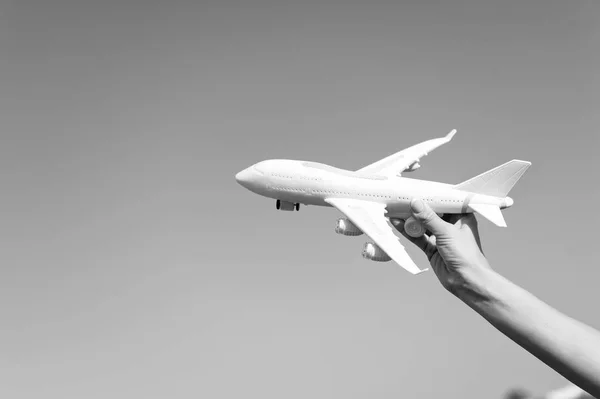 Plane in female hand clear blue sky background copy space. Travel and vacation. Book tickets now. Toy white plane fly vacation destinations. Travel comfortable premium class airlines. Discover world — Stock Photo, Image
