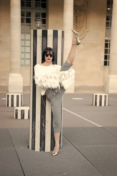 在法国巴黎的条纹柱子上，女孩的腿被劈开 — 图库照片