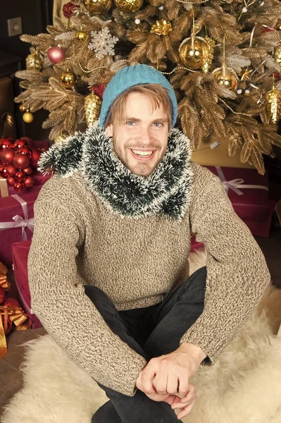 Χαμόγελο ο άνθρωπος με το καπέλο, πουλόβερ, στολίδια στο χριστουγεννιάτικο δέντρο — Φωτογραφία Αρχείου
