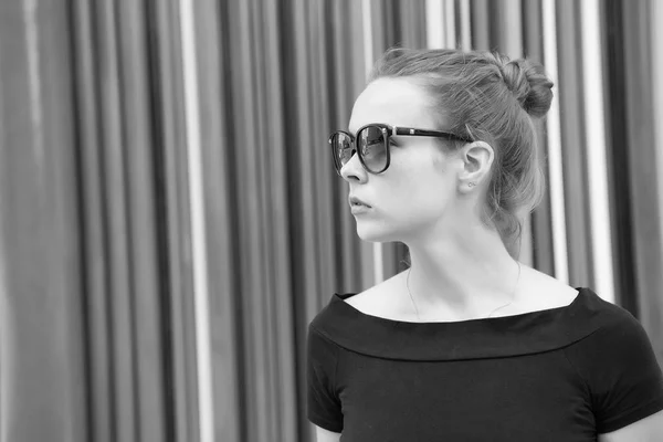 Lady προσφορά μυστηριώδες πρόσωπο με μαύρα γυαλιά μπροστά από ριγέ πολύχρωμο τοίχο στο Παρίσι. Γυναίκα κομψή εμφάνιση μοντέρνο ντύσιμο. Έννοια αστικού στυλ μόδας. Αστική μόδα των μεγάλων πόλεων — Φωτογραφία Αρχείου