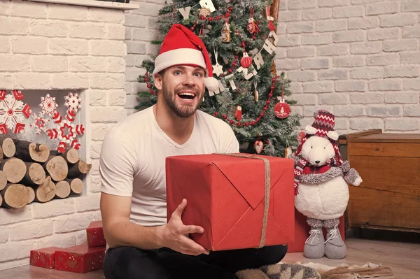 Man in santa hat sit on floor at fireplace — Stock Photo, Image