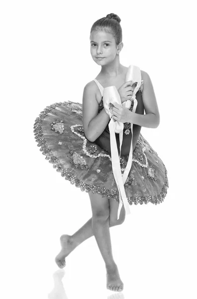 Ejercicios para desarrollar habilidades de baile de zapatos puntiagudos. Niño feliz sostiene zapatos de ballet atributo importante excelente bailarina. Bailarina niña sostiene zapatos puntiagudos en el fondo blanco de la mano. Asesoramiento profesional —  Fotos de Stock