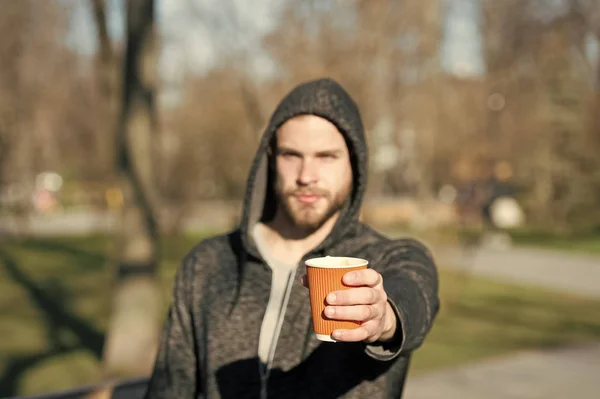 Café ou xícara de chá na mão de homem desfocado no parque — Fotografia de Stock