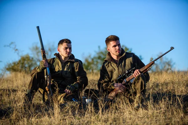 Rest for real men concept. Discussing catch. Hunters with rifles relaxing in nature environment. Hunter friend enjoy leisure in field. Hunters gamekeepers relaxing. Hunting with friends hobby leisure — Stock Photo, Image