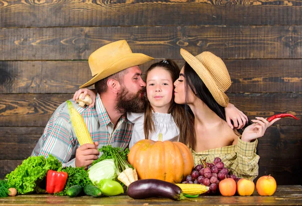 Grown with love. Family farmers with harvest wooden background. Family rustic style farmers at market with vegetables fruits and greenery. Parents and daughter harvest festival. Family farm concept